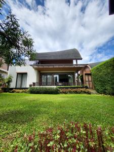 a house with a green lawn in front of it at Villa Vimala Hills Semeru in Bogor