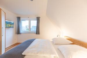 a bedroom with a large bed and a window at Getidenhus Sünn in Sankt Peter-Ording