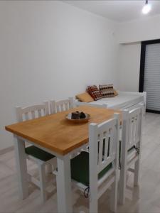 mesa de comedor con sillas blancas y cama en Ayres Apart en Chivilcoy