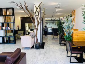 a lobby with chairs and a tree in the middle at Golden Crown Hotel Alseeb Muscat in Seeb