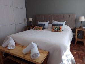 1 dormitorio con 1 cama blanca grande y toallas en una mesa en Hermoso departamento en Córdoba, Centro 3 pax en Córdoba