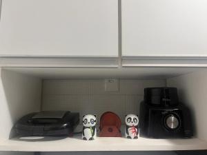 a kitchen shelf with a microwave and a toaster at Wintervilleflat904 in Gravatá
