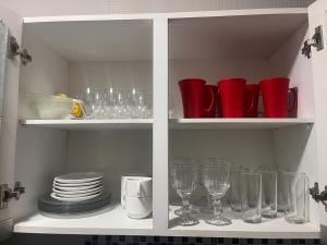 a white cabinet filled with glasses and plates at Wintervilleflat904 in Gravatá