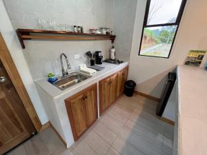 una pequeña cocina con fregadero y encimera en Pacheco Tours Rainforest Cabins, en Drake