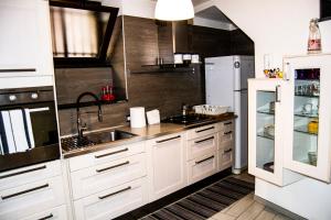 a kitchen with white cabinets and a sink and a refrigerator at Luan House in San Giorgio a Cremano