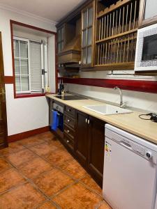uma cozinha com um lavatório e uma máquina de lavar louça em Casa del Aceite de Oliva Virgen Extra em Jaén