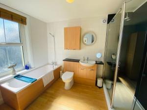 y baño con bañera, aseo y lavamanos. en Blackford House a large home Portland Dorset, en Portland