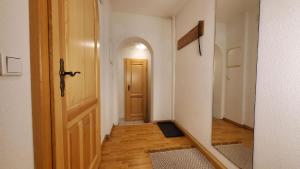 an empty hallway with a door and a room with wood floors at Die alte Kantorei - historische Ferienwohnung in Kahla +9 photos