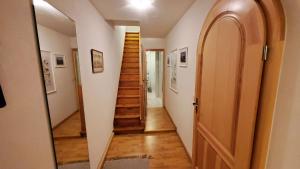 a hallway with a wooden staircase in a house at Die alte Kantorei - historische Ferienwohnung in Kahla