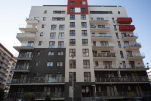 a tall apartment building with a red at Alezi Residence in Braşov