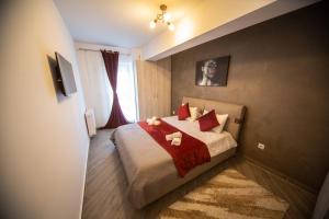 a bedroom with a bed with two stuffed animals on it at Alezi Residence in Braşov