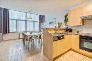 a kitchen with a table and a dining room at Gaugain E 601 in Nieuwpoort