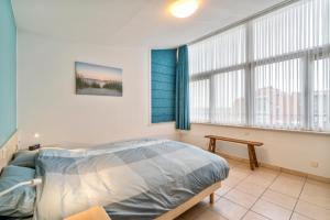 a bedroom with a bed and a large window at Gaugain E 601 in Nieuwpoort