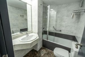 bagno con lavandino, servizi igienici e specchio di Micampus Leganés a Leganés