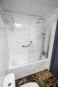 uma casa de banho com um chuveiro, um WC e uma banheira em Micampus Leganés em Leganés