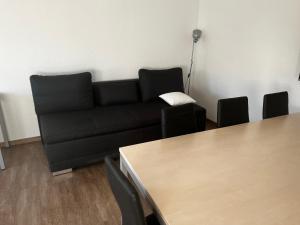 デッサウにあるZiebigk Appartement Deluxeのリビングルーム(黒いソファ、テーブル付)