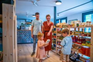 un grupo de personas de pie en una tienda con un niño en EuroParcs Kohnenhof, en Obereisenbach