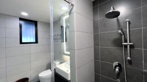 a bathroom with a shower and a toilet and a sink at The Yanné, Onsen Hotel in Genting Highlands