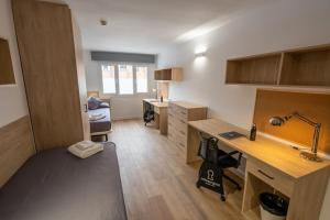 a room with a desk and a bed in it at Micampus Leganés Student Residence in Leganés