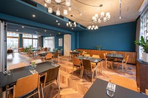 a restaurant with tables and chairs and a blue wall at magdas HOTEL Vienna City - First Social Business HOTEL in Austria in Vienna