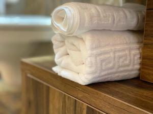 a stack of white towels on a wooden shelf at Vila Imperial One Luxury Boutique Hotel in Făgăraş