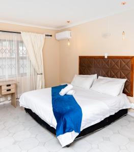 a bedroom with a large bed with a blue blanket at Nkosazana Guest House in Durban