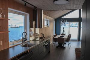 a kitchen with a view of the ocean and a dining room at Visit Mortsund, Lofoten in Leknes