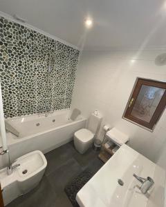 a bathroom with a tub and a toilet and a sink at La Casona El Carrascal in La Gandara