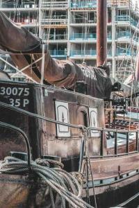 un barco está atracado en un puerto al lado de un edificio en AMAZING PRIVATE LUXURY BOAT ACCOMMODATION, en Ámsterdam