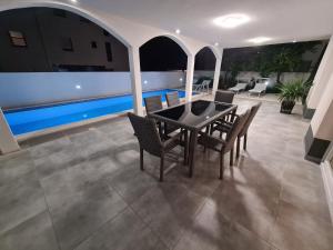 a patio with a table and chairs and a pool at Villa Sabine in Trogir