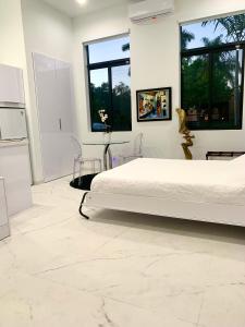 a white bedroom with a bed and two windows at Men only clothing option guesthouse near Wilton Manors in Fort Lauderdale +58 photos