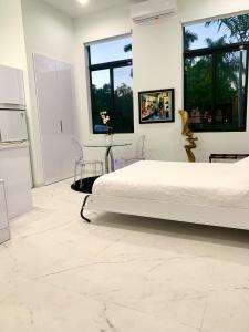 a white bedroom with a bed and two windows at Men only clothing option guesthouse near Wilton Manors in Fort Lauderdale