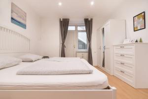 ウィーンにあるSpacious central apartmentの白いベッドルーム(大型ベッド1台、ドレッサー付)
