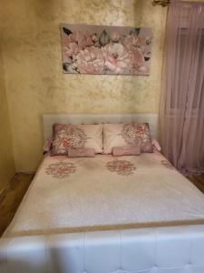 łóżko w sypialni z obrazem na ścianie w obiekcie Apartman Golden Rose w mieście Loznica