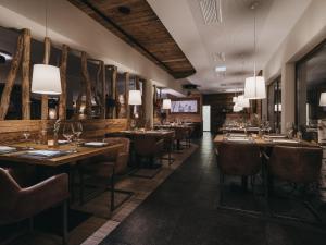 un restaurante con mesas de madera, sillas y luces en VAYA Sölden en Sölden