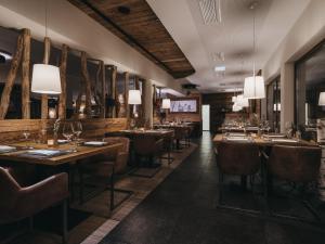 a restaurant with wooden tables and chairs and lights at VAYA Sölden inklusive Summer Card in Sölden