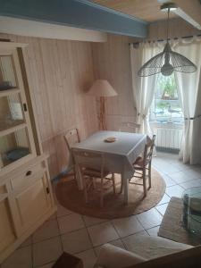 comedor con mesa, sillas y ventana en penty vero, en Plobannalec-Lesconil