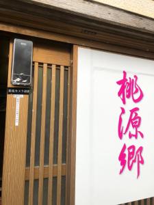 un cartel en la puerta de un edificio con un cartel en él en 桃源郷２, en Toba
