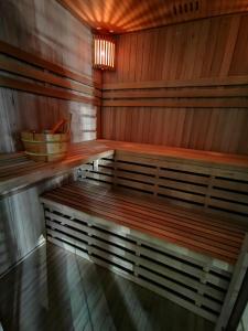an empty sauna with a wooden bench and a basket at Aviator in Pabianice