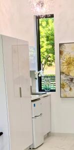 a kitchen with white cabinets and a window at Men only clothing option guesthouse near Wilton Manors in Fort Lauderdale