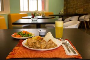 una mesa con un plato de comida y un vaso de cerveza en Hotel Serra Nova, en Cajamarca