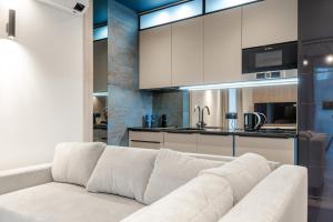 een woonkamer met een witte bank en een keuken bij Apartament Blue Moon in Jelenia Góra