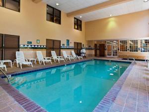 a large swimming pool with chairs and chairs in a building at Heathman Lodge in Vancouver