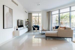 sala de estar blanca con sofá y sillas en HiGuests - Elegant Apt With Terrace Minutes from Burj Khalifa, en Dubái