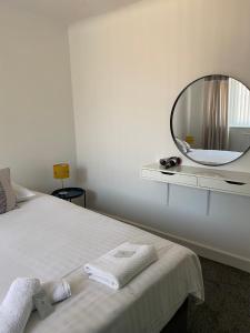 a bedroom with a bed with a mirror on the wall at M&J Apartment in Blackpool