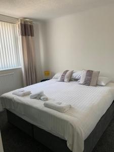 a bedroom with a large white bed with towels on it at M&J Apartment in Blackpool