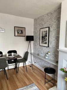 a living room with a table and chairs and a brick wall at M&J Apartment in Blackpool