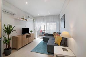un soggiorno con un divano e una TV di Apartamento Peron a Quarteira