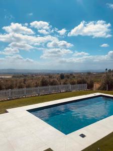 uma piscina num quintal com uma cerca branca em Olea b&b em Montecosaro