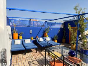 Riad Villa El Arsa في مراكش: فناء به أثاث زرقاء والنباتات على شرفة